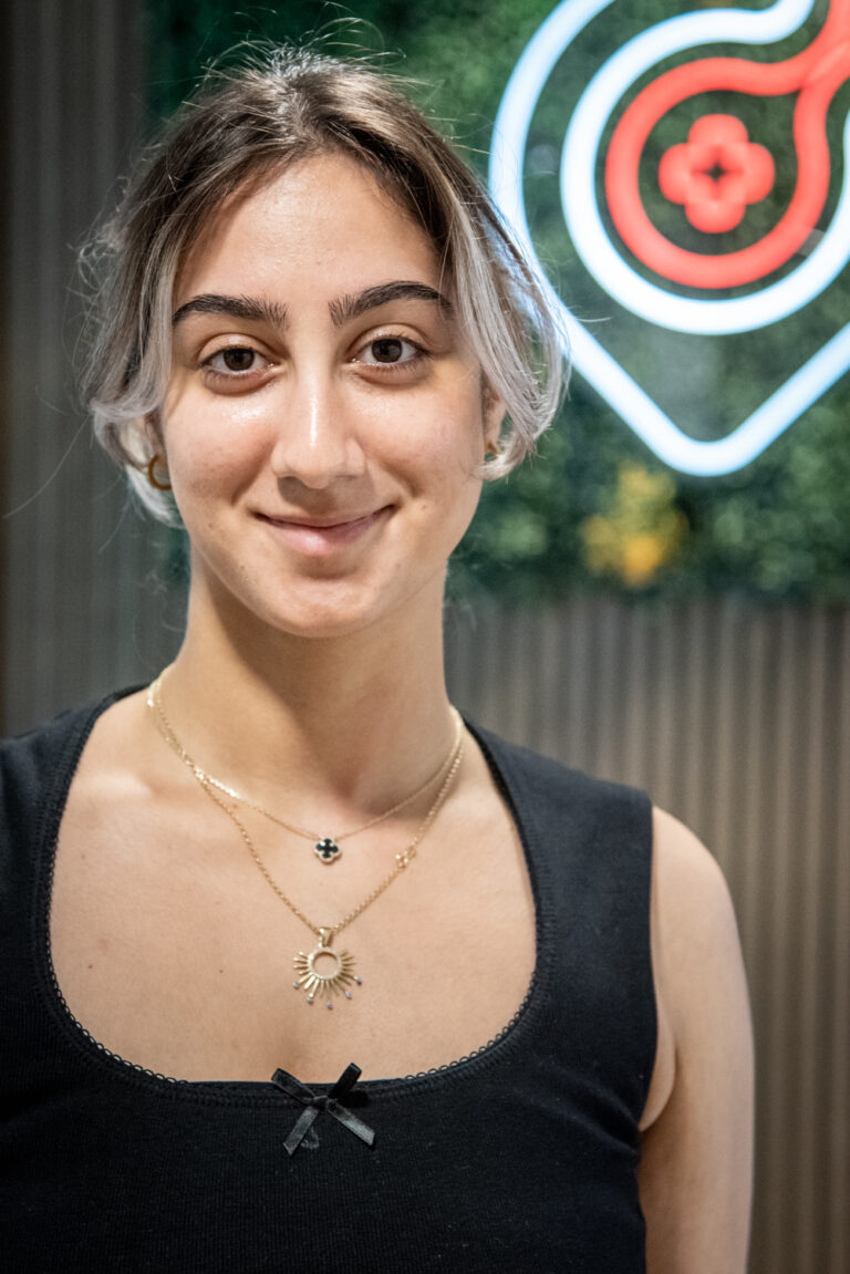 Young woman with sun-shaped necklace smiling