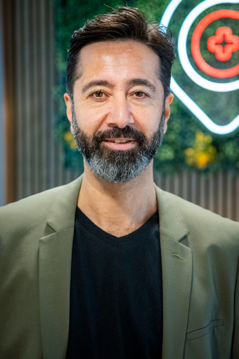 Smiling man with beard in green jacket