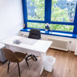Bright office with white desk and blue window