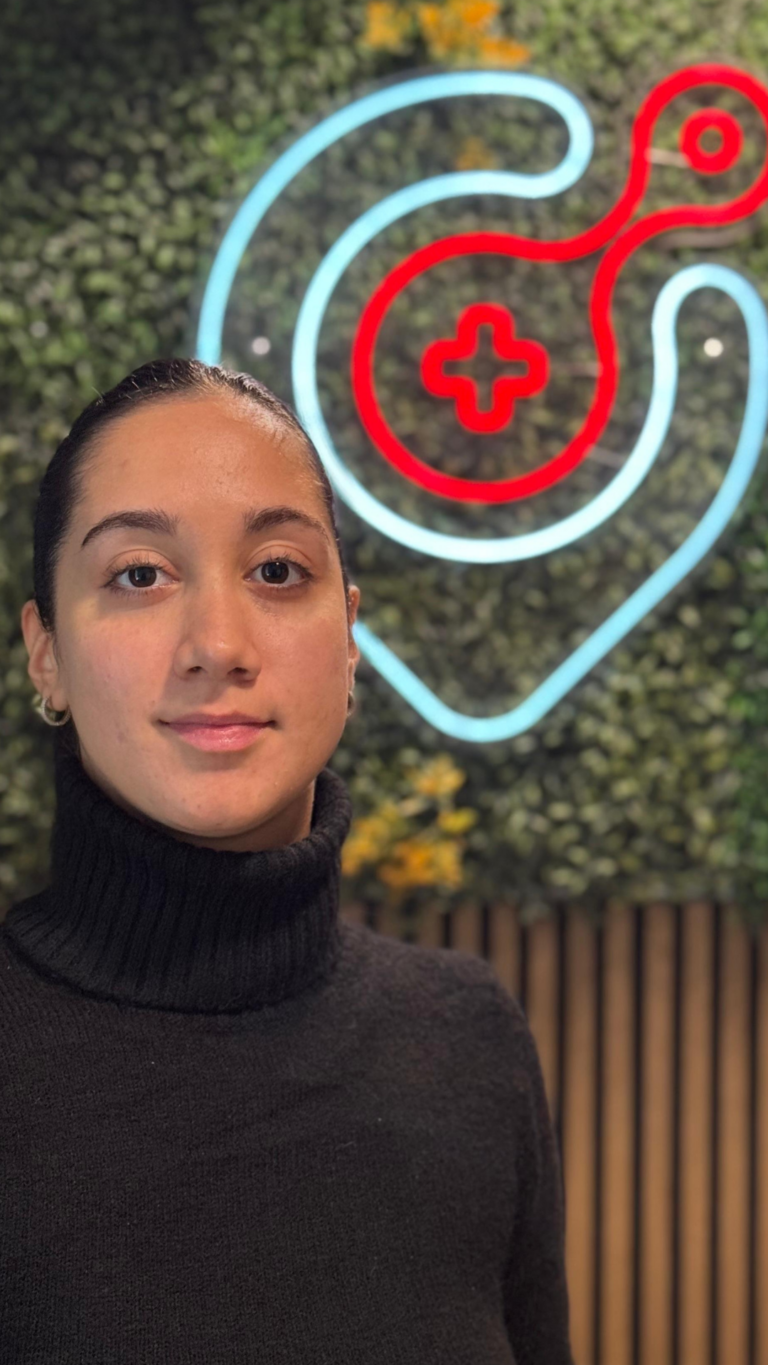 Frau vor neonbeleuchtetem Stethoskop-Symbol