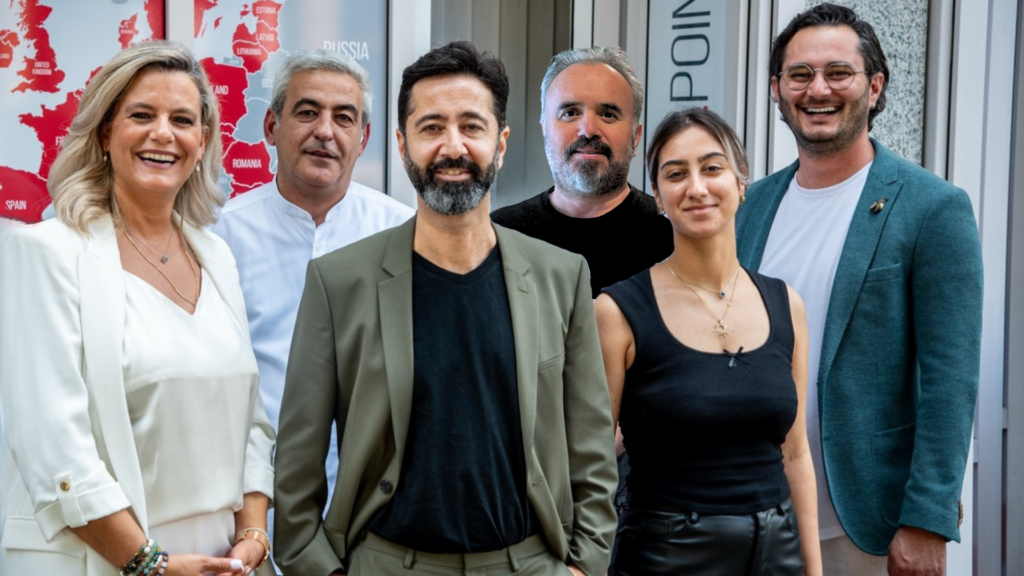 Three men and three women stand smiling next to each other.